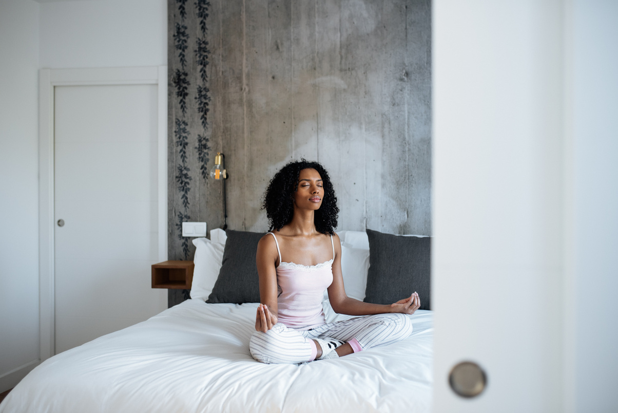 Attractive black woman on bed meditating